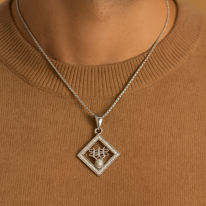 Silver necklace with a pendant on a person wearing a brown sweater